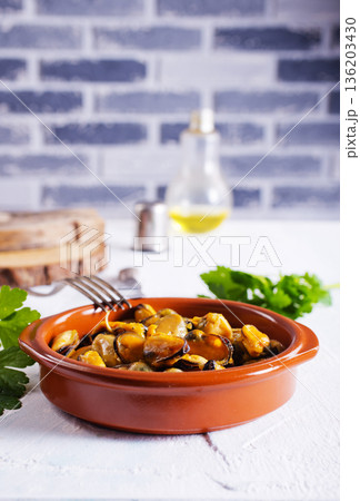 Mussels with sauce in a dish on a light background. Mussels with sauce in a dish on a light background. 136203430
