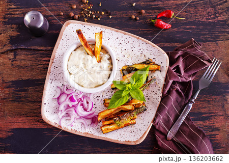 Baked crispy eggplant sticks served with white sauce. Vegetarian healthy dish. Baked crispy eggplant sticks served with white sauce. Vegetarian healthy dish. 136203662