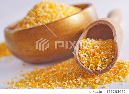 Raw cornmeal flour used in polenta, in wooden bowl 136203682