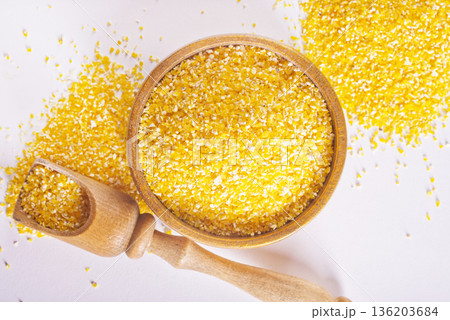 Raw cornmeal flour used in polenta, in wooden bowl 136203684