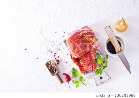 Fresh raw bacon sliced with spices and herbs on a lightr concrete background Fresh raw bacon sliced with spices and herbs on a lightr concrete background 136203969