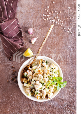 Russian salad Olivier on a Christmas or New Year table. Made with vegetables, mayonnaise, peas, mortadella sausage and eggs served in a white bowl. Russian salad Olivier on a Christmas or New Year table. Made with vegetables, mayonnaise, peas, mortadella sausage and eggs served in a white bowl. 136203996