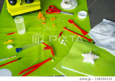 Table with microscope, crystals and laboratory tools after home science experiment. Realistic STEM learning environment and hands on chemistry activity in everyday life. Table with microscope, crystals and laboratory tools after home science experiment. Realistic STEM learning environment and hands on chemistry activity in everyday life. 136204120