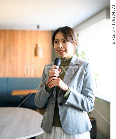 女性がマイクで話す 136204573