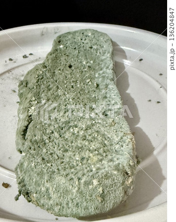 A close-up shot of moldy bread. Baked goods covered in blue mold due to long-term and improper storage. A close-up shot of moldy bread. Baked goods covered in blue mold due to long-term and improper storage. 136204847