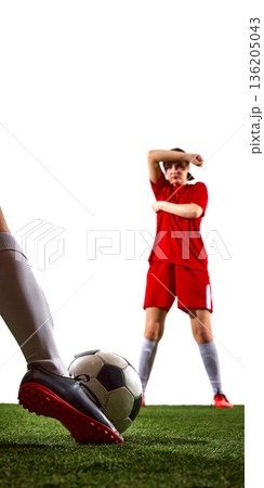 Female soccer player preparing free kick with opponent wall in background. 136205043
