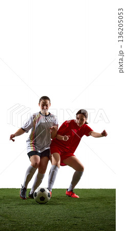 Two female soccer players competing for ball on white background. 136205053