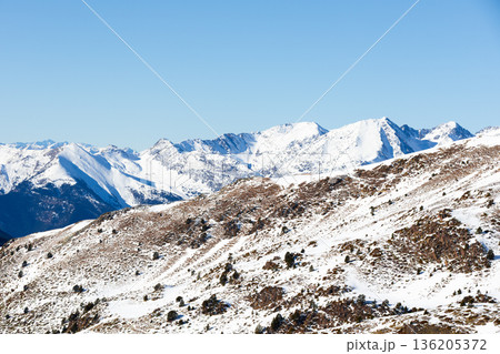 Snow capped mountain range under clear blue sky 136205372