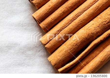Cinnamon cassia sticks stacked together, showcasing their rich brown color and curled ends. Ideal for culinary and aromatic uses. Cinnamon cassia sticks stacked together, showcasing their rich brown color and curled ends. Ideal for culinary and aromatic uses. 136205800