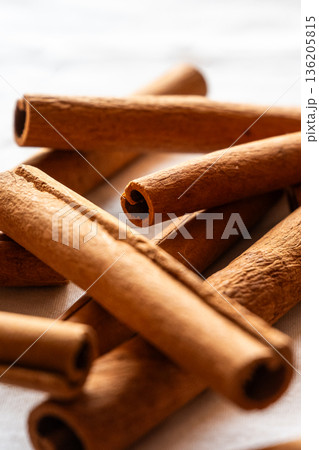 Cinnamon cassia sticks stacked together, showcasing their rich brown color and curled ends. Ideal for culinary and aromatic uses. Cinnamon cassia sticks stacked together, showcasing their rich brown color and curled ends. Ideal for culinary and aromatic uses. 136205815