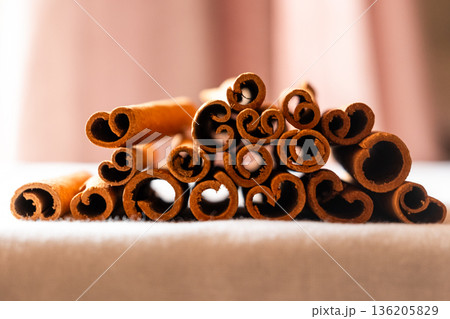 Cinnamon cassia sticks stacked together, showcasing their rich brown color and curled ends. Ideal for culinary and aromatic uses. Cinnamon cassia sticks stacked together, showcasing their rich brown color and curled ends. Ideal for culinary and aromatic uses. 136205829