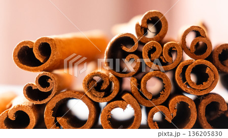 Cinnamon cassia sticks stacked together, showcasing their rich brown color and curled ends. Ideal for culinary and aromatic uses. Cinnamon cassia sticks stacked together, showcasing their rich brown color and curled ends. Ideal for culinary and aromatic uses. 136205830