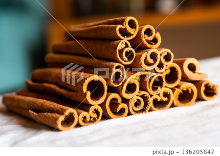 Cinnamon cassia sticks stacked together, showcasing their rich brown color and curled ends. Ideal for culinary and aromatic uses. Cinnamon cassia sticks stacked together, showcasing their rich brown color and curled ends. Ideal for culinary and aromatic uses. 136205847