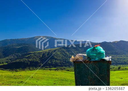Overflowing trash bin in rural landscape under clear blue sky in Kyrgyzstan Overflowing trash bin in rural landscape under clear blue sky in Kyrgyzstan 136205887