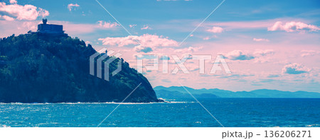 Landscape with sea and cliffs. Rocky seashore on a sunny day. Beautiful nature, landscape, stormy sea. Donostia San Sebastian, Basque Country, Spain, Europe. Horizontal banner 136206271