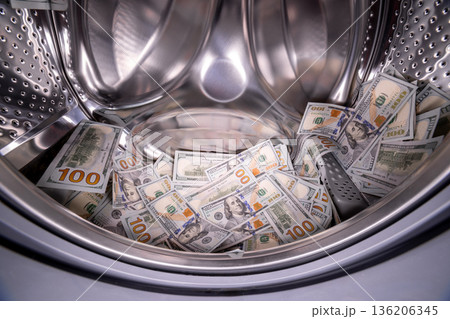 Hundred US dollar banknotes inside of domestic washing machine, closeup 136206345