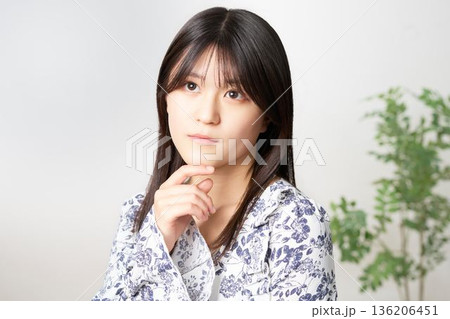 斜め上を見つめて考え事をする20代日本人女性 136206451