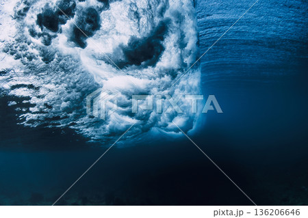 Underwater view inside crashing ocean wave, blue water with light rays 136206646