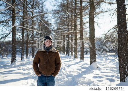 Man standing in snowy park in winter Man standing in snowy park in winter 136206754