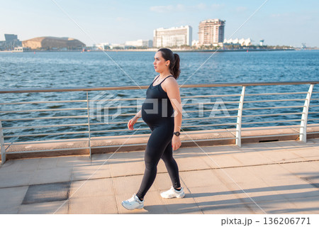 Pregnant Woman Walking Along The Waterfront In Stylish Active wear. 136206771
