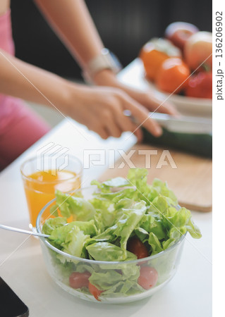 Fit young Asian women in activewear sitting on yoga mat and eating fresh vegetable salad after workout, representing clean eating, fitness lifestyle, wellness routine and health balance. Fit young Asian women in activewear sitting on yoga mat and eating fresh vegetable salad after workout, representing clean eating, fitness lifestyle, wellness routine and health balance. 136206902