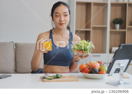 Fit young Asian women in activewear sitting on yoga mat and eating fresh vegetable salad after workout, representing clean eating, fitness lifestyle, wellness routine and health balance. Fit young Asian women in activewear sitting on yoga mat and eating fresh vegetable salad after workout, representing clean eating, fitness lifestyle, wellness routine and health balance. 136206906
