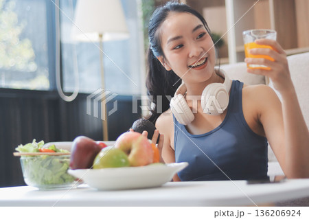 Fit young Asian women in activewear sitting on yoga mat and eating fresh vegetable salad after workout, representing clean eating, fitness lifestyle, wellness routine and health balance. Fit young Asian women in activewear sitting on yoga mat and eating fresh vegetable salad after workout, representing clean eating, fitness lifestyle, wellness routine and health balance. 136206924