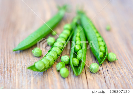 Fresh green peas arranged on wooden board close up Fresh green peas arranged on wooden board close up 136207120