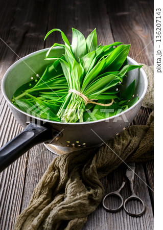 Fresh wild garlic in colander with rustic background 136207143