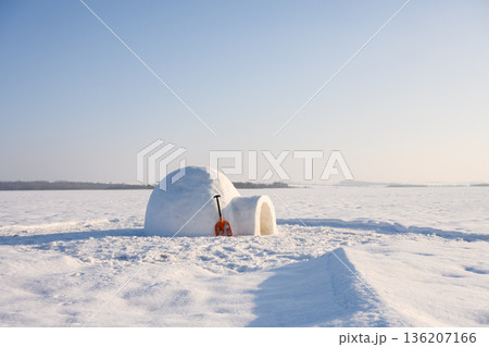 Igloo with snow shovel on the winter field 136207166