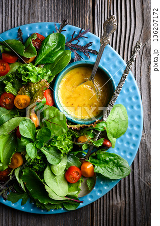 Mixed salad greens with cherry tomatoes and honey mustard dressing Mixed salad greens with cherry tomatoes and honey mustard dressing 136207172
