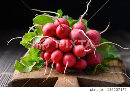 Organic radish bunch arranged on rustic board Organic radish bunch arranged on rustic board 136207173
