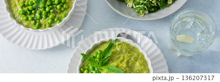 Bright green puree of green pea and broccoli fills a bowl, garnished with fresh mint and whole peas, showcasing a fresh and healthy soup perfect for lunch or dinner, banner Bright green puree of green pea and broccoli fills a bowl, garnished with fresh mint and whole peas, showcasing a fresh and healthy soup perfect for lunch or dinner, banner 136207317