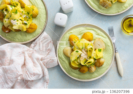 Baked potatoes are topped with fermented zucchini slices and served on a green pea sauce with broccoli for a healthy breakfast option that is hearty Baked potatoes are topped with fermented zucchini slices and served on a green pea sauce with broccoli for a healthy breakfast option that is hearty 136207396