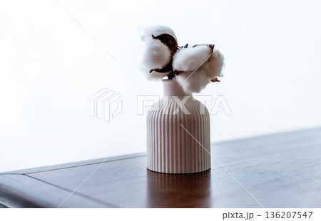 White cotton flowers in minimalistic vase. Natural home decor concept. Serene simple design for interior magazine. White cotton flowers in minimalistic vase. Natural home decor concept. Serene simple design for interior magazine. 136207547