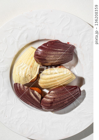Assorted chocolate madeleine cakes on white plate 136208359