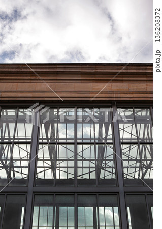 Glass building against a cloudy sky 136208372