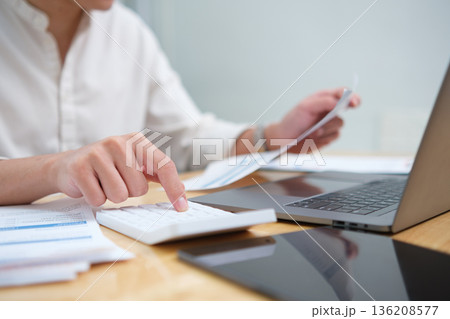 Businessman hands or finance with calculator or documents for project budget or expenses in office. Man, accountant or tax collector with laptop for financial analysis, bills or audit Businessman hands or finance with calculator or documents for project budget or expenses in office. Man, accountant or tax collector with laptop for financial analysis, bills or audit 136208577
