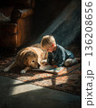Toddler enjoys story time with a loyal dog in a cozy room 136208656