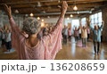 Joyful yoga session uniting seniors and young adults in a serene studio 136208659