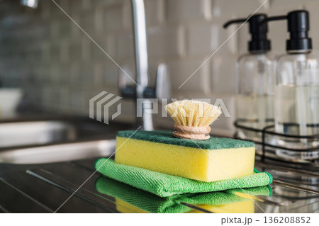 Wooden brush for washing dishes in the kitchen next to sink. Eco friendly, zero waste or conscious consumption concept. Copy space 136208852