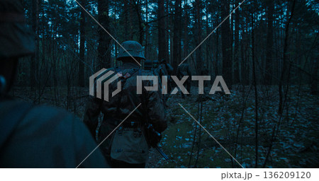 Wehrmacht soldiers patrolling forest at night during WWII 136209120
