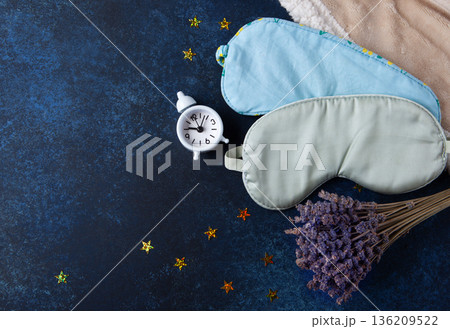 World Sleep Day concept. Bedtime accessories, sleep masks, and classic alarm clock on dark blue wooden background World Sleep Day concept. Bedtime accessories, sleep masks, and classic alarm clock on dark blue wooden background 136209522