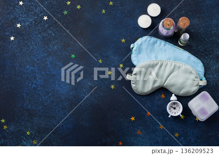 World Sleep Day concept. Bedtime accessories, sleep masks, and classic alarm clock on dark blue wooden background World Sleep Day concept. Bedtime accessories, sleep masks, and classic alarm clock on dark blue wooden background 136209523