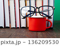 World Book and Copyright Day education concept with stacked books, reading glasses, red coffee cup. Intellectual work, publishing culture, protected knowledge 136209530