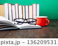 World Book and Copyright Day education concept with stacked books, reading glasses, red coffee cup. Intellectual work, publishing culture, protected knowledge 136209531