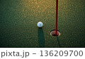 朝露に光るグリーンでカップ際に止まるボールと赤旗の静かな瞬間 136209700