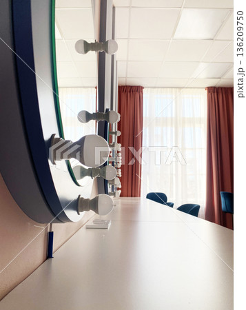 Modern vanity mirror with bright bulbs reflecting natural light, showcasing elegant design elements and a stylish atmosphere in a contemporary interior space Modern vanity mirror with bright bulbs reflecting natural light, showcasing elegant design elements and a stylish atmosphere in a contemporary interior space 136209750