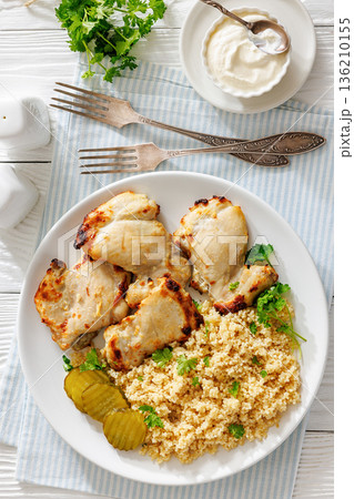 Boneless chicken thighs and couscous on a plate 136210155