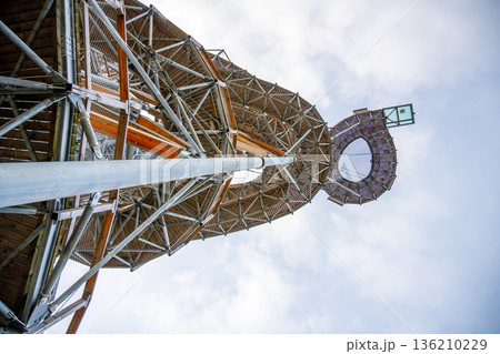 People visit a tall tower structure with a viewing platform at the top. The tower stands high against a cloudy sky. Visitors enjoy the view from the surrounding area. People visit a tall tower structure with a viewing platform at the top. The tower stands high against a cloudy sky. Visitors enjoy the view from the surrounding area. 136210229